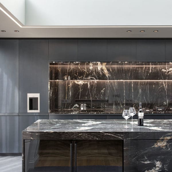 Küche mit Küchenblock aus Naturstein und Rückraumbereich mit Stahlfronten und Naturstein in Bildabwicklung in Luxushaus Amsterdam mit Gaggenau Geräten